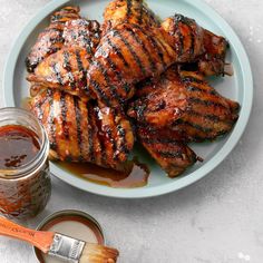 grilled chicken with bbq sauce on a plate next to a jar of barbecue sauce