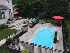 an above ground pool surrounded by patio furniture and umbrellas