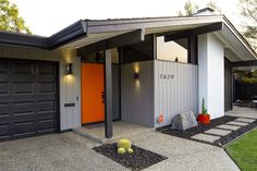 a house with two garages and an orange door