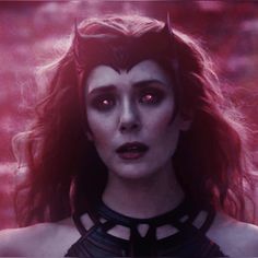 a woman with red eyes and dark makeup in a scene from the movie maleficent