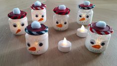 there are many snowman jars with candles in them