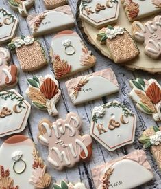 some decorated cookies are laying on a table with wedding rings and other items around them