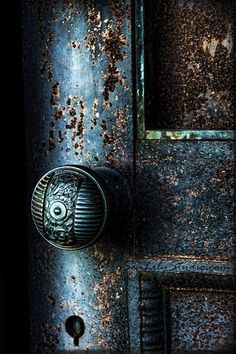 an old door is covered in rust and has a keyhole on the front panel