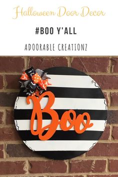 a black and white striped halloween door hanger with the word boo in orange on it