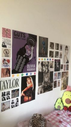 a bedroom with posters on the wall and a teddy bear