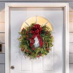 a christmas wreath on the front door of a house