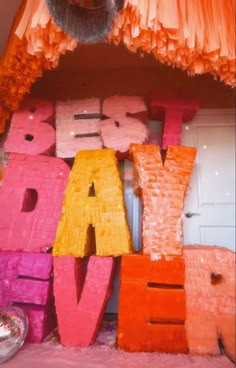 the letters are made out of orange and pink tissue paper