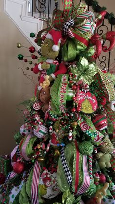 a christmas tree decorated with green and red ribbons