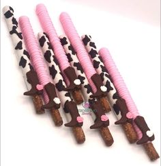 several pink and black candy sticks with chocolate on them