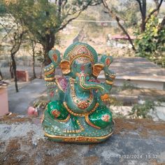 an elephant statue sitting on top of a rock