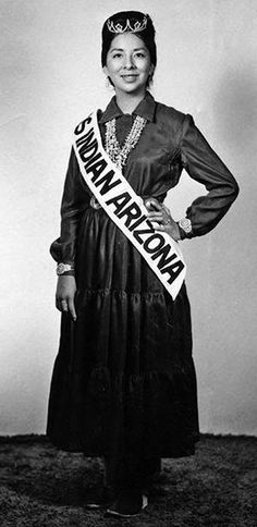 an old black and white photo of a woman wearing a sash