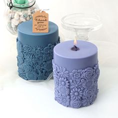 two blue and purple candles sitting next to each other