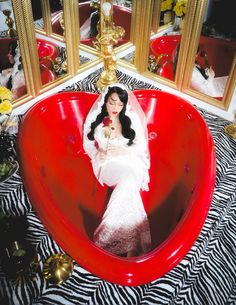 a woman in a wedding dress is sitting in a heart shaped bathtub