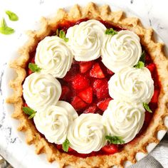 a pie topped with whipped cream and strawberries