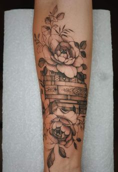 a woman's leg with a tattoo on it and flowers in the middle of it