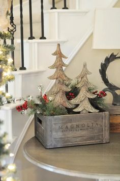 a christmas scene with pine trees in a wooden box on the table next to stairs