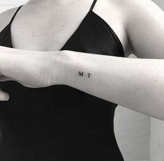 a woman's arm with the word m t tattooed on her left forearm and wrist