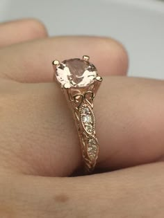 a close up of a person's hand holding an engagement ring