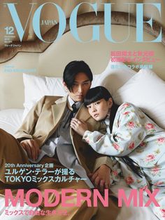 a man and woman laying on top of a bed next to each other in front of a magazine cover