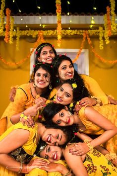 a group of women in yellow dresses posing for a photo with their arms around each other