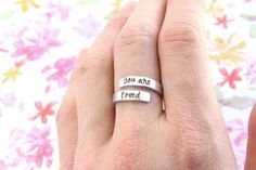 "You are loved. An easy-to-wear adjustable ring with an inspirational message perfect for a daughter or friend. Details -- Made from aluminum which is non-tarnish and hypoallergenic. Ring is formed to your size, but is adjustable without the use of any special tools. Total length from end-to-end is 3 inches and 1/8\" wide. Personalize -- Select size from menu. Handcrafted -- These are not machine engraved; instead, each letter is lined up one-by-one and hammered into the metal by hand. For this Personalized Adjustable Rings For Friendship, Adjustable Personalized Rings For Friendship, Marathon Gift, Shoe Tags, Running Gifts, Gifts For Runners, Wrap Rings, Daughter Gifts, Rings For Her