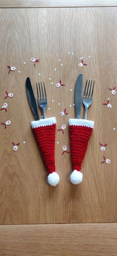 two forks and spoons are placed in the shape of santa's hats