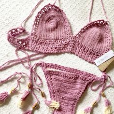 two pieces of pink crocheted bikinisuit with tassels