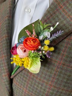 a man in a suit with flowers on his lapel flower bouquet is seen from the waist up