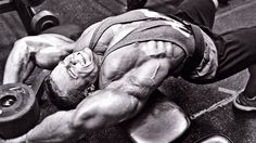 a man laying on top of a bench with a barbell