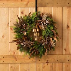 a wreath with bells hanging on a wooden wall