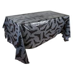 a table covered in black and white bat print with silver foil on it's edges