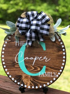 a wooden sign that says the cooper family with a bow on it's front