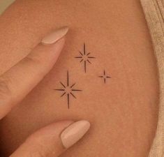 a woman's arm with three small stars on the back of her left shoulder