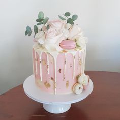 a pink and white cake with flowers on top