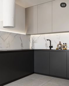 a kitchen with marble counter tops and black cabinets, along with white lights on the wall