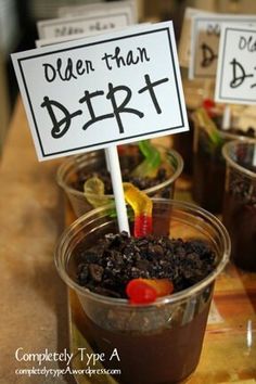 three plastic cups filled with dirt sitting on top of a table