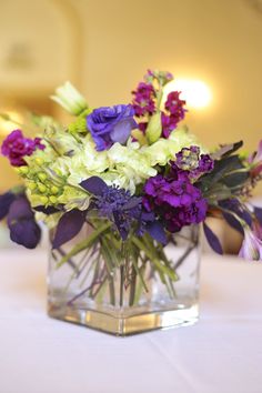 a vase filled with purple and white flowers