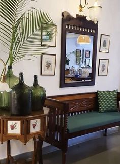 a living room filled with furniture next to a mirror and potted plant on top of a table