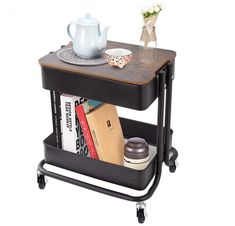 a table with a book shelf on wheels and a tea pot sitting on top of it