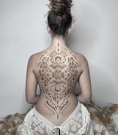 the back of a woman's body with tattoos on it