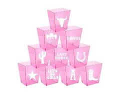 pink paper bags with white letters and cowboy symbols on them are stacked in the shape of a pyramid