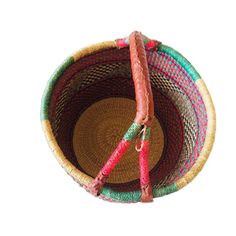 a woven basket with two handles is shown on a white background and has pink, green, red, and yellow trim