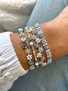 a woman's arm with three bracelets made out of blue and white beads