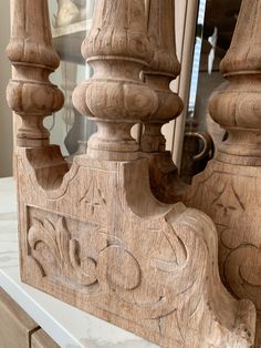 an ornate carved wooden frame on a white marble countertop in front of a mirror