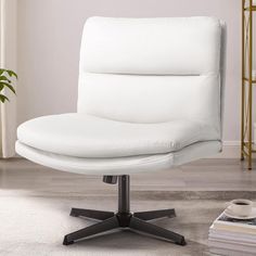 a white office chair sitting on top of a carpeted floor next to a potted plant