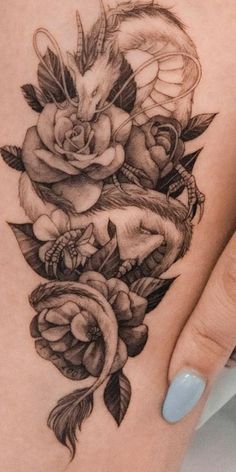 a close up of a person's foot with tattoos on it and flowers in the middle