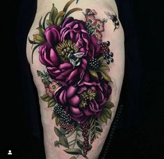 a woman's thigh with flowers and leaves on her leg, in black background