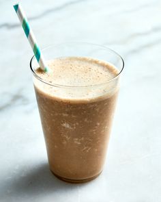 a smoothie in a glass with a blue and white striped straw