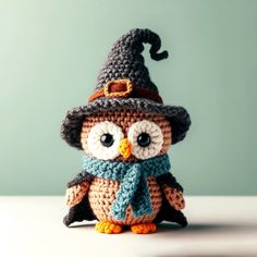 a crocheted owl with a hat and scarf on it's head, sitting on a table