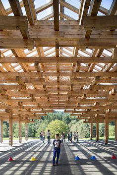 a person is standing under a wooden structure